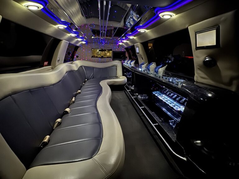 Lincoln navigator SUV stretch limo interior with combination of withe and blue lights and light brown interior