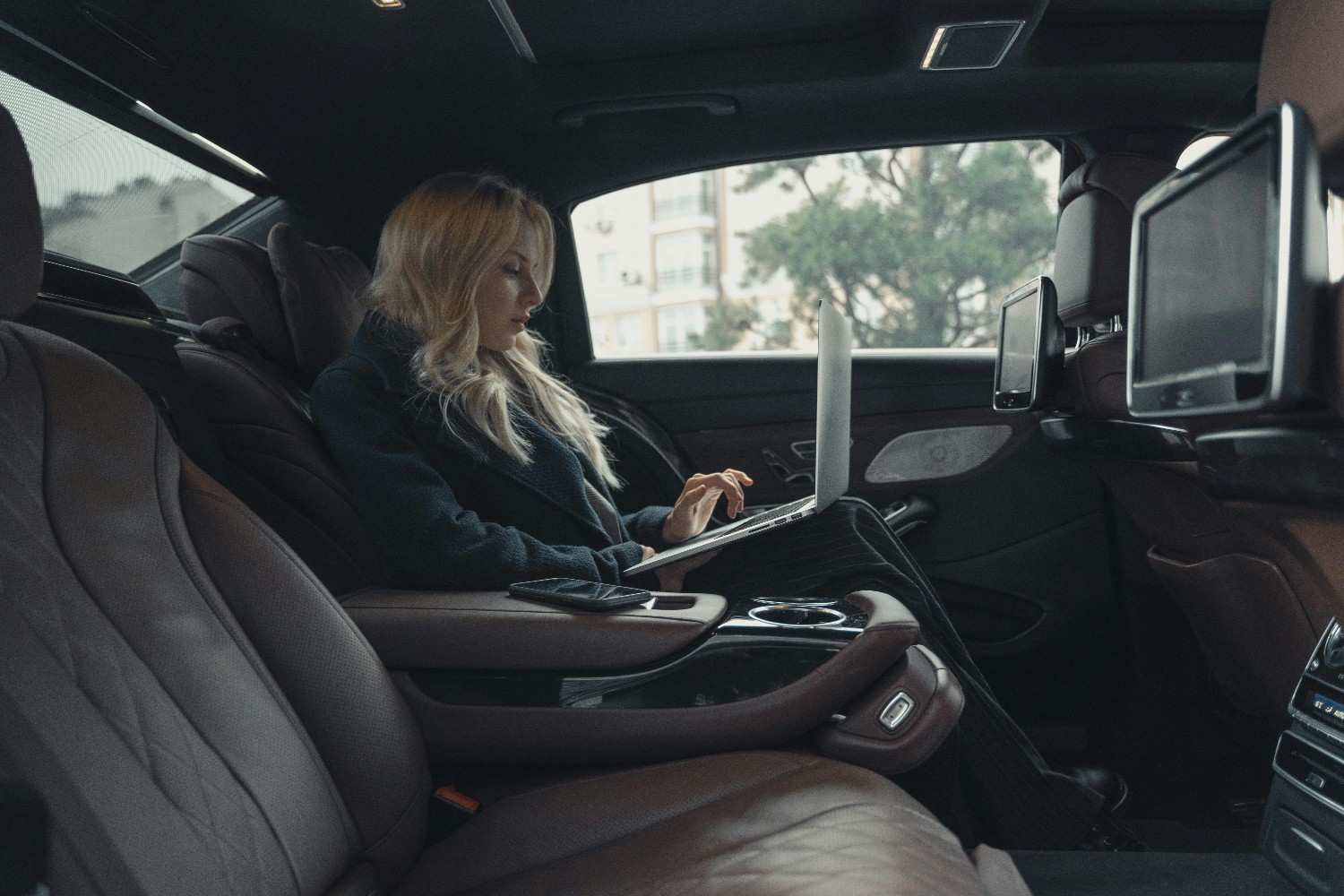 Executive and Corporate Luxury Rides a woman sitting in a car with a laptop