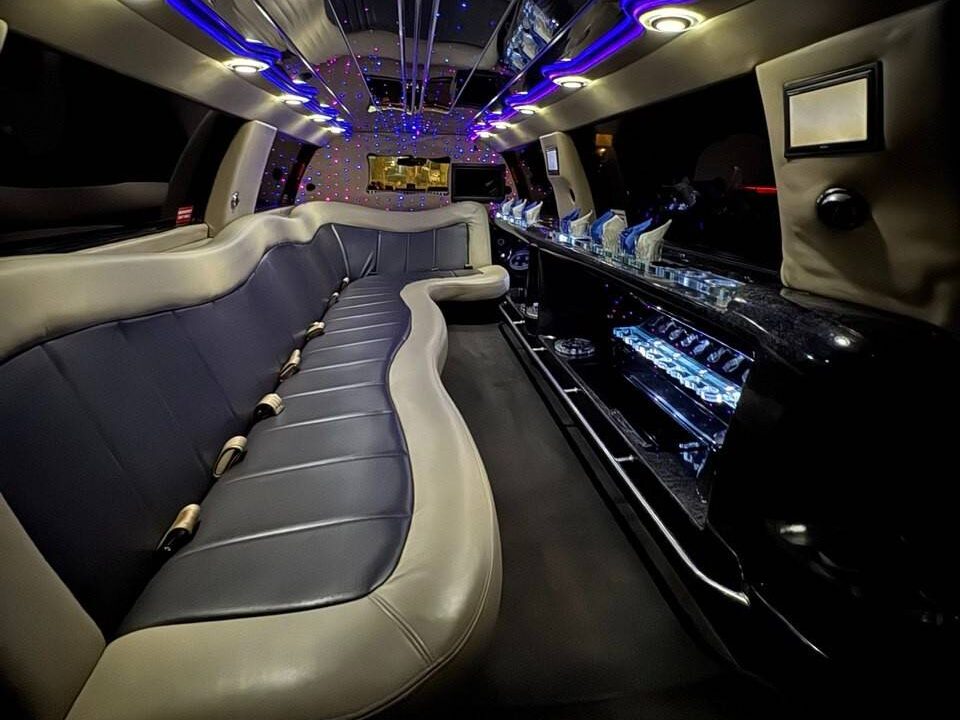 Home Lincoln navigator SUV stretch limo interior with combination of withe and blue lights and light brown interior